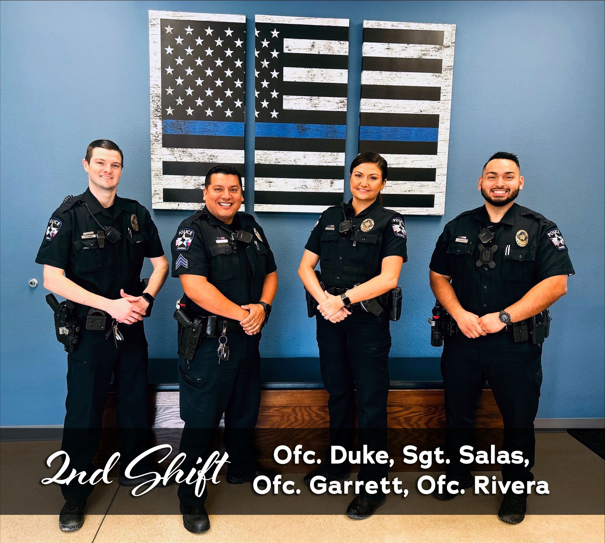 2nd Patrol Shift standing in front of flag decor in police lobby